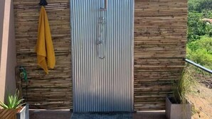 A modern outdoor shower with a rain showerhead, surrounded by wooden panels and a view of a lush green landscape. - Boho-Luxe Pool Villa with Simply Amazing Views by Setting Sun Boutique Homes (ตำบล เกาะลันตาใหญ่)