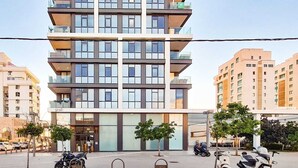 A multi-story building with a modern architectural design, featuring balconies and large windows. - Hayarkon Royal in Tel Aviv-yafo (Tel Aviv)