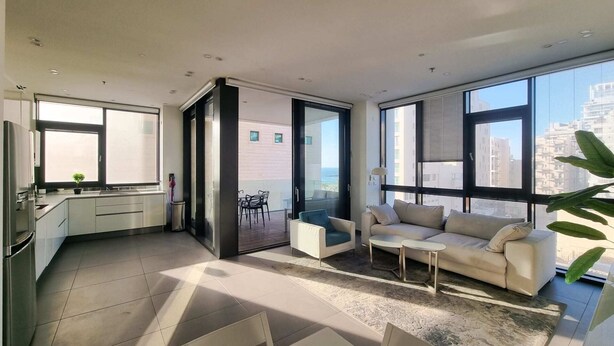 A modern apartment with a kitchen, dining area, and living room with large windows. - Hayarkon Royal in Tel Aviv-yafo (Tel Aviv)