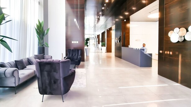 A modern hotel lobby with a reception desk, seating area, and potted plants. - Hayarkon Bronze in Tel Aviv-yafo (Tel Aviv)
