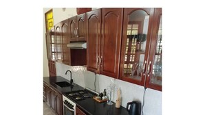 Una cocina con armarios de madera, encimera negra, estufa y lavabo.