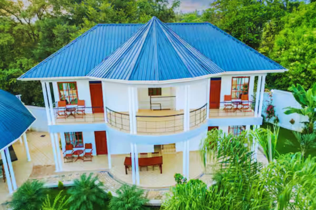 A two-story building with a blue roof, multiple balconies, and a covered outdoor area.