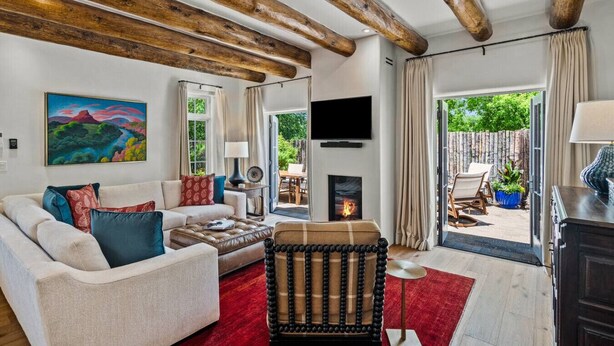 Ein Wohnzimmer mit Kamin, einer Couch, einem Couchtisch und einem an der Wand befestigten Fernseher.