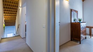 A hallway with a wooden ceiling, a wooden cabinet with a mirror, and a tiled floor. - Beautiful apartment for 7 people with A/C, WIFI and pets allowed (Donoratico)