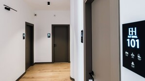 Moderni hotellikäytävä, jossa on digitaalinen opastekyltti, joka näyttää huoneen numeron 101.