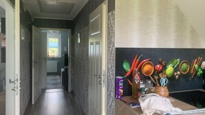 A hallway with a wooden floor, a blackboard with spices and kitchen utensils, and a door leading to another room. - Matti vacation home in the Lusatian Lakeland (Schipkau)