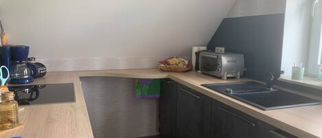 A small kitchenette with a coffee maker, toaster, and a window with a view.