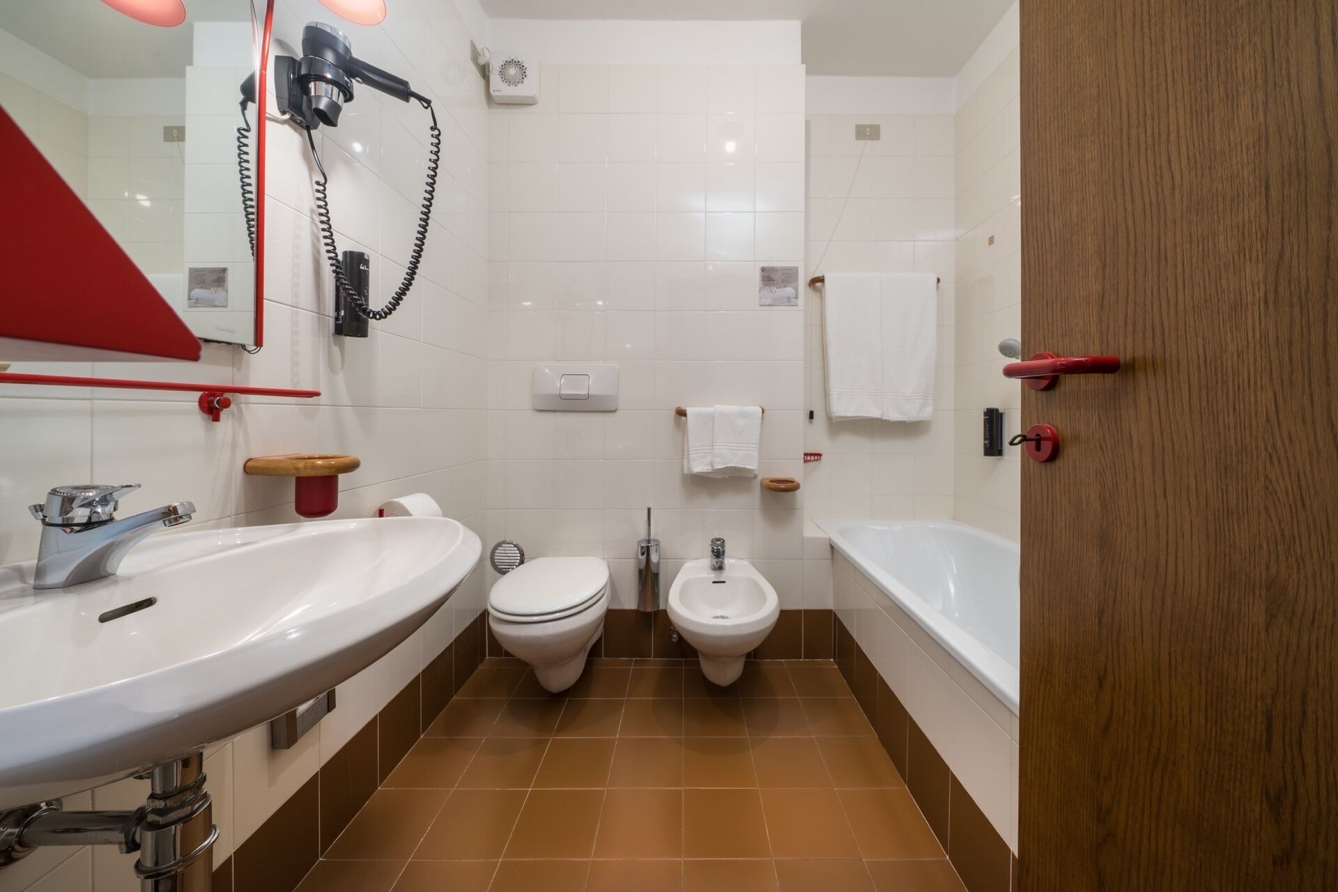 A bathroom with a sink, toilet, bidet, and bathtub.