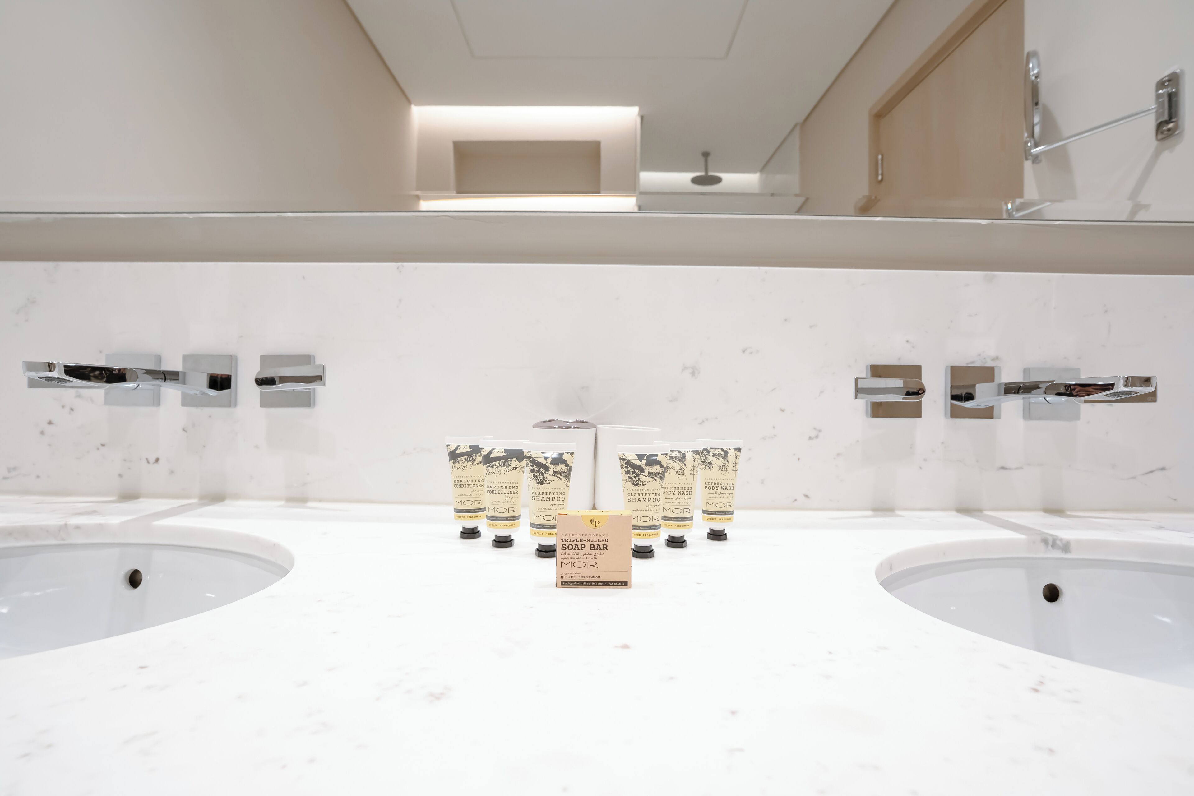 Ein modernes Badezimmer mit zwei großen Waschbecken, einem Spiegel und einer Duschkabine.
