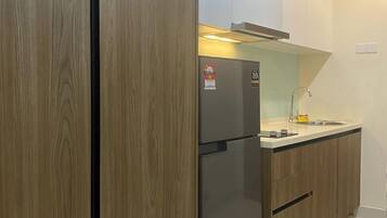 A modern kitchen with wooden cabinets, a stainless steel refrigerator, and a white countertop.