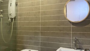 Een badkamer met toilet, wastafel en douche.