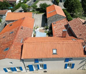 Ein Wohngebiet mit mehreren Häusern, die rote Ziegeldächer und blaue Fensterläden haben.