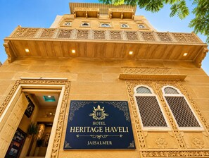 Un cartel de hotel con elaboradas tallas y un balcón.