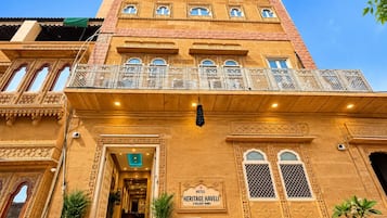 Un hotel de estilo arquitectónico tradicional, con balcones ornamentales y un letrero que indica que es un hotel histórico.