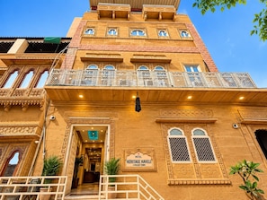 Un hôtel de style architectural traditionnel, doté de balcons richement décorés et d’une enseigne indiquant qu’il s’agit d’un hôtel classé monument historique.