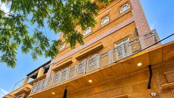 Um hotel de vários andares com arquitetura tradicional, uma escadaria e uma placa indicando ser um hotel histórico.