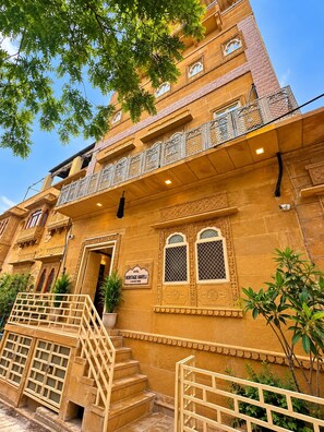 Un hotel de varios pisos con arquitectura tradicional, una escalera y un letrero que indica que es un hotel histórico.