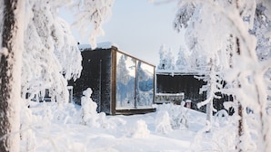 Paisagem coberta de neve com um edifício moderno com grandes janelas.
