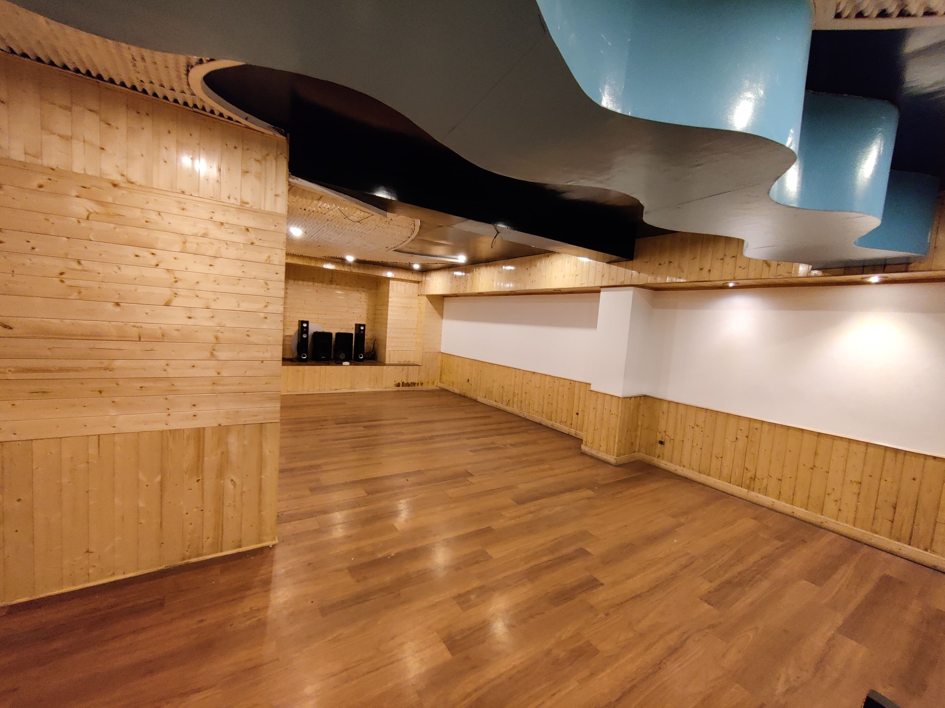A spacious room with wooden paneling and a wooden floor.