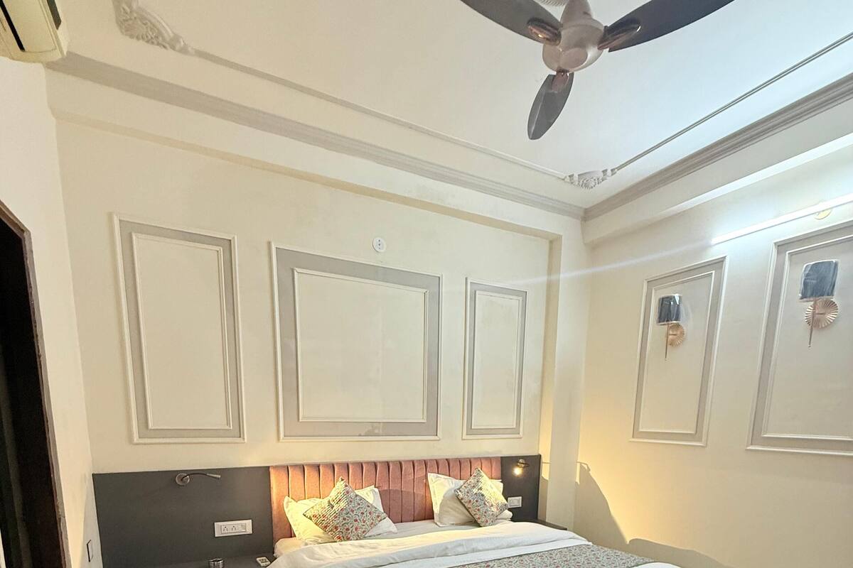 A bedroom with a bed, bedside tables, a ceiling fan, and a rug.