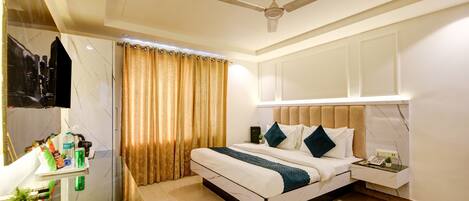 A hotel room with a bed, bedside table, and a glass partition.