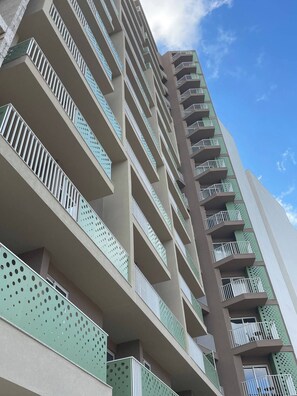 Un edificio de varios pisos con balcones y cielo despejado.