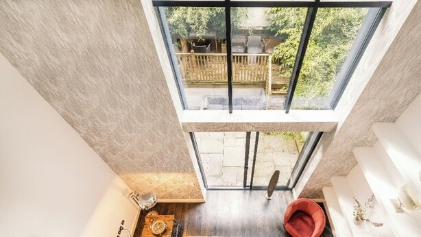 A modern room with a skylight, a red chair, a wooden side table, and a framed artwork. - The Primrose Hill Elegant House (Greater London)