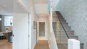 Ein modernes Interieur mit Treppe, Essbereich und Küche.