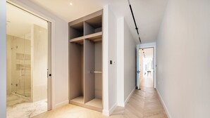 A modern hallway with a glass shower, a walk-in closet, and a wooden floor. - Soak in the Spalike Marble Bath at Plush Penthouse (Greater London)
