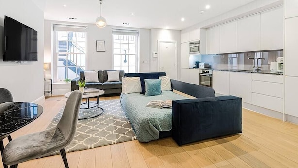 Un appartement moderne comprenant un espace de vie, un coin repas et une cuisine.
