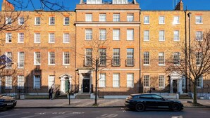 A row of brick townhouses with uniform windows and a central entrance. - Best Penthouse in Bloomsbury (Greater London)