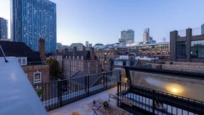 A rooftop terrace with a view of a cityscape, including modern and traditional buildings. - A Slick House Trendy Spitafields (Greater London)