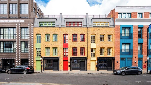A row of colorful terraced houses with a clear sky. - A Slick House Trendy Spitafields (Greater London)