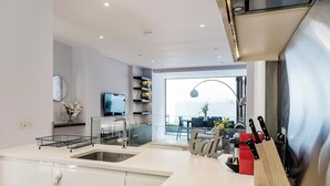 A modern kitchen with a built-in stove, a sink, and a dining area with a view.