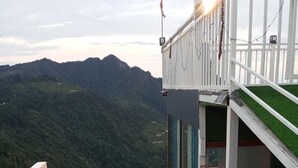Eine Treppe führt zu einem Gebäude mit Blick auf eine gebirgige Landschaft.