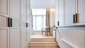 Ein modernes Interieur mit einer Treppe zu einer Sitzgelegenheit, einschließlich eines Stuhls und eines Tisches.