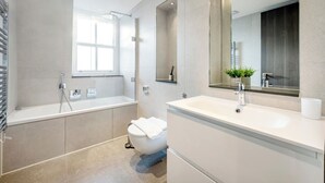 Une salle de bain moderne avec une baignoire, des toilettes et un lavabo.