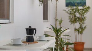 A table with a coffee maker, two cups, and a spoon, surrounded by potted plants and a painting on the wall. - Holiday Home 'Buena Vista House' with Mountain View, Private Terrace and Wi-Fi (Santa Brígida)