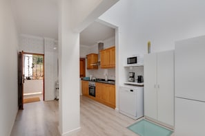 Una cocina moderna con armarios de madera, microondas, lavavajillas y cafetera.