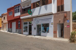 Une pharmacie avec une enseigne indiquant « Farmacia El Madroñal » et une entrée bien visible.