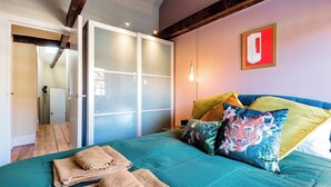A bedroom with a bed, towels, and a sliding door leading to another room. - Embrace authenticity and quirky charm (Greater London)