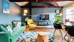 A modern living room with a green sofa, a yellow armchair, and a dining area with a table and chairs. - Embrace authenticity and quirky charm (Greater London)