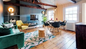 A cozy living room with a TV, yellow armchair, and a dining area with a table and chairs. - Embrace authenticity and quirky charm (Greater London)