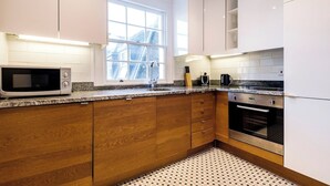 A modern kitchen with a microwave, coffee maker, and oven. - Embrace authenticity and quirky charm (Greater London)