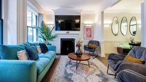 A spacious living room with a sofa, armchairs, a coffee table, and a fireplace. - The Liverpool Trendy House (Greater London)