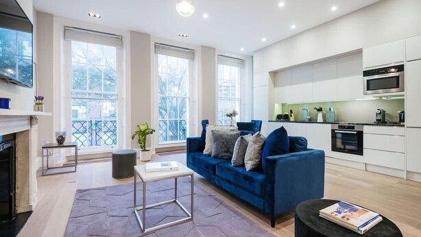 A modern living room with a blue sofa, a small coffee table, and a fireplace.
