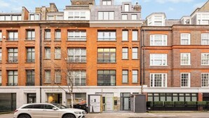 A row of red brick buildings with multiple windows and balconies. - West end Deluxe flat N.2 (Greater London)