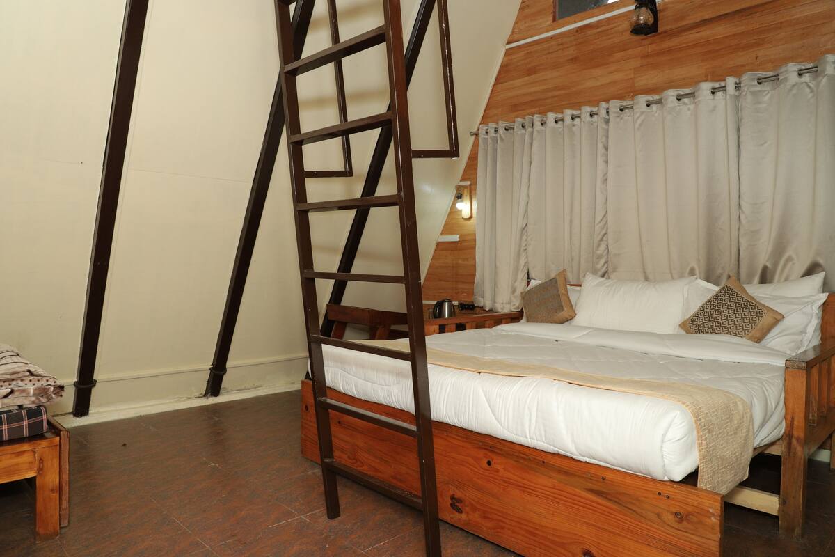 A wooden bed with a ladder, white bedding, and a headboard with curtains.
