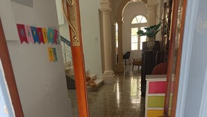 A hallway with patterned floor tiles, a star-shaped rug, and a wooden door. - Charming Maltese townhouse (Il-Mosta)