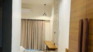 A hallway with a wooden cabinet, a bench, and a ceiling fan. - SRK Farm and Resort (Anjar)
